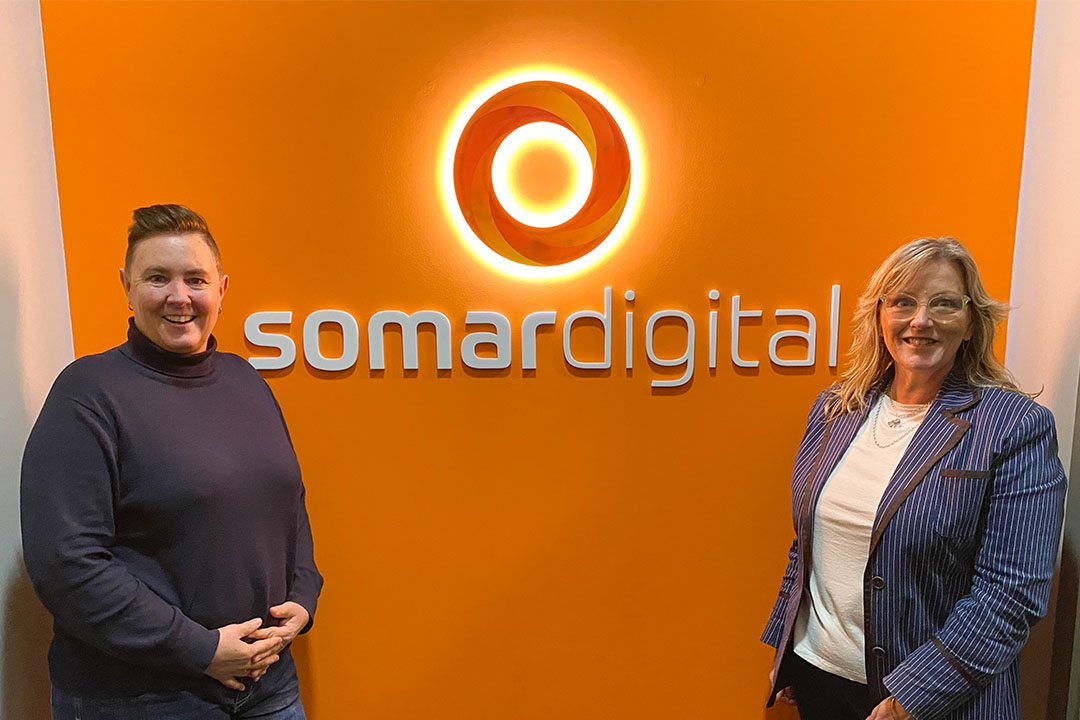 Fiona Reid and Denelle Joyce standing in front of Somar Digital logo